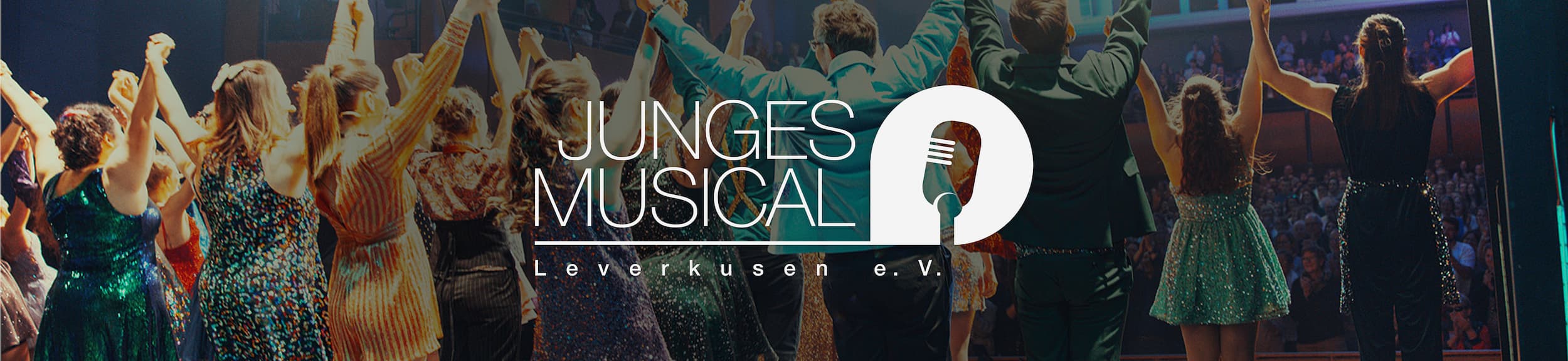 Bühnenaufnahme mit Darsteller:innen eines Musicals, die sich an den Händen halten und sich vor Publikum verbeugen, darüber das Logo „Junges Musical Leverkusen e. V.“ mit Mikrofon-Symbol.